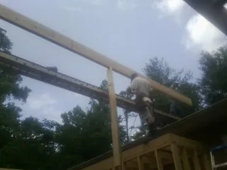 Carpenter setting a ridge beam over a new addition frame — Ice Dam Removal by Roofing Brothers in Matawan