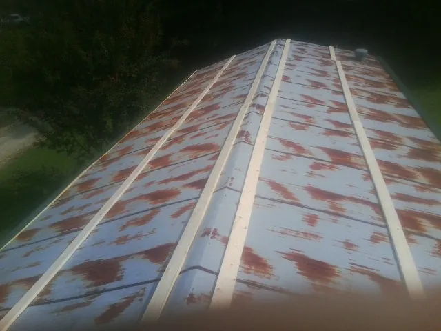 Rusted metal roof panels with new wood purlins before replacement — Storm Damage Roof Repair in Matawan by Roofing Brothers