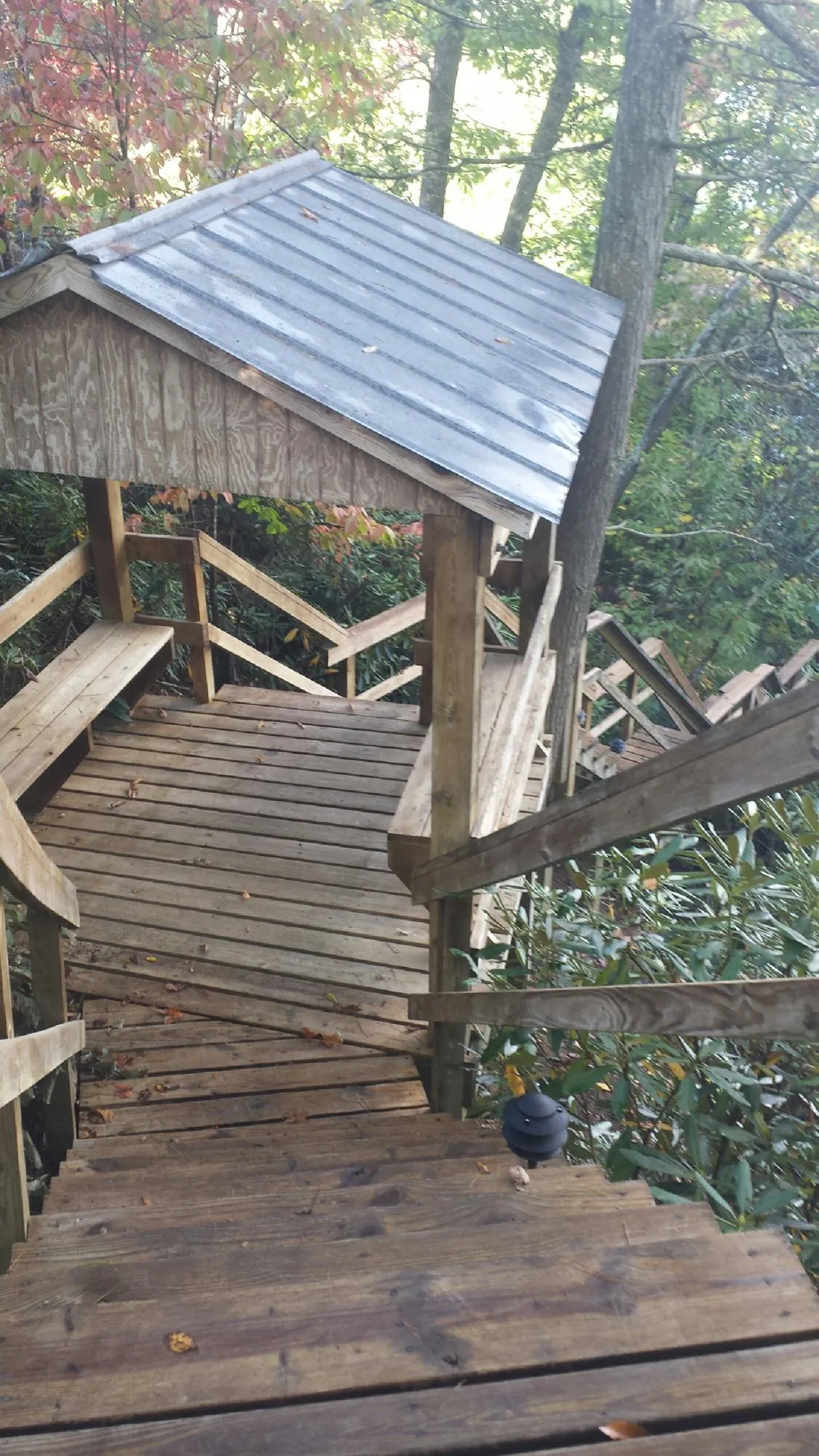 Metal roofed shelter over wooden steps on a wooded walkway — Skylight Repair & Installation work by our crew in Matawan